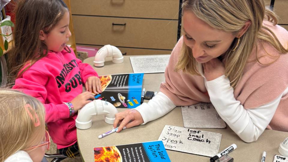 Nicholle Bonilla works with two students