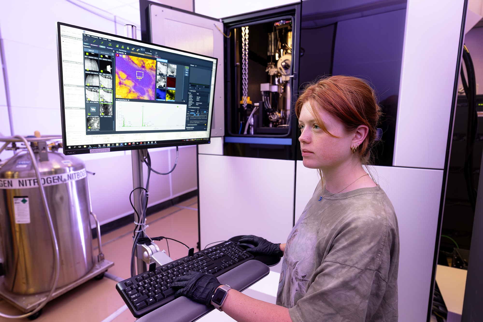 Emma McCarthy works at computer near LSU's Spectra 300 Scanning Transmission Electron Microscope