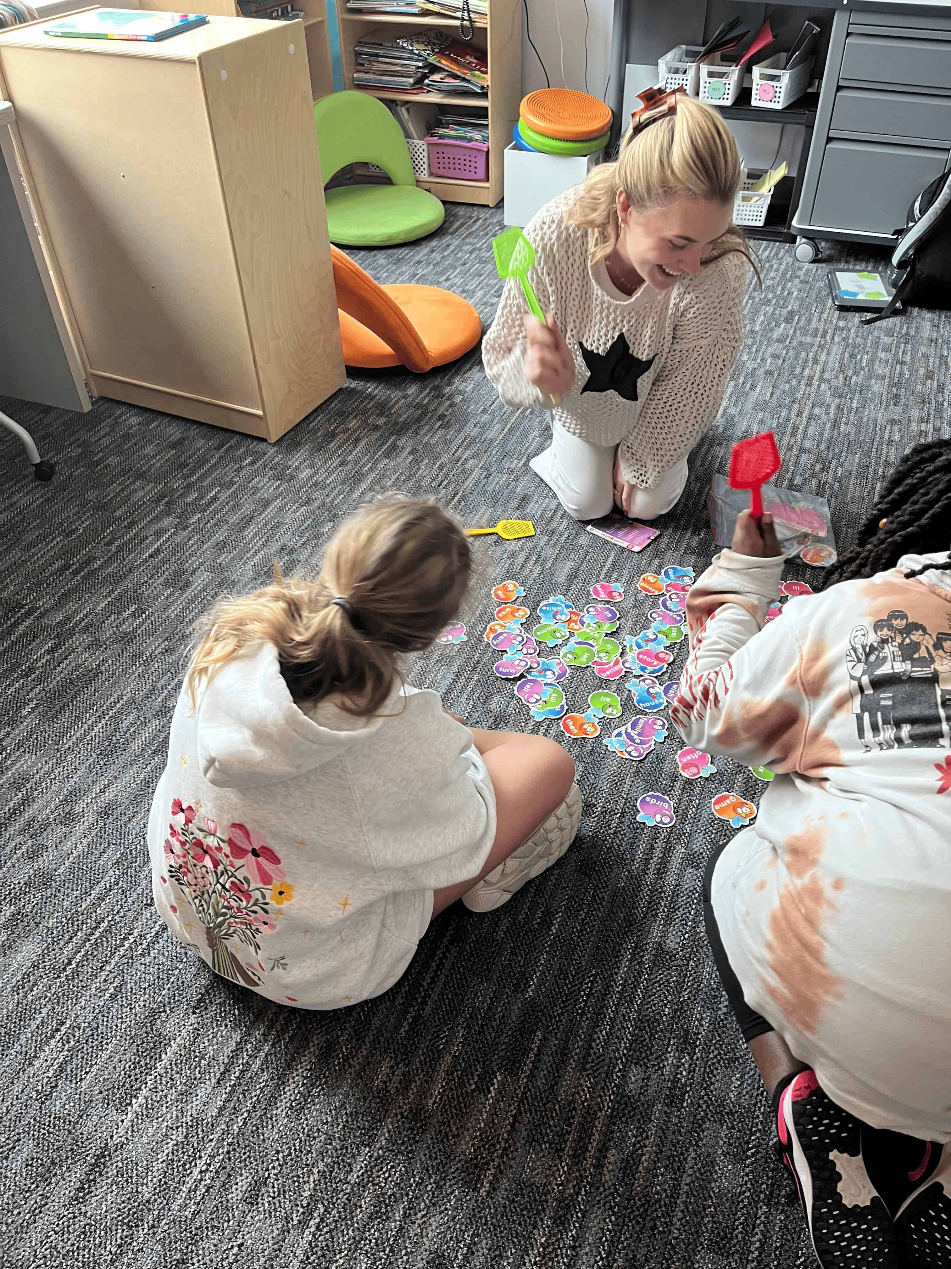 Kaleigh Stallings playing a game with students on the floor