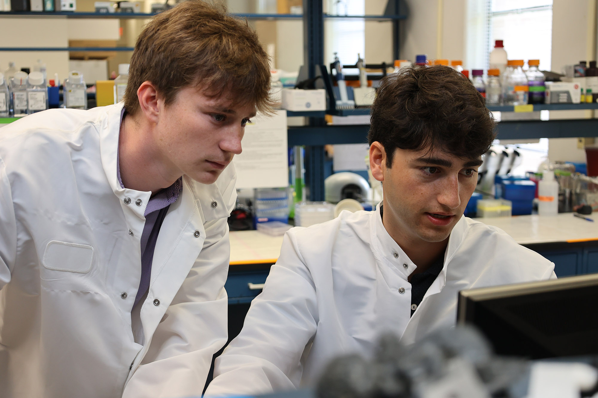 Luke Lissard and James Balart work on a lab computer
