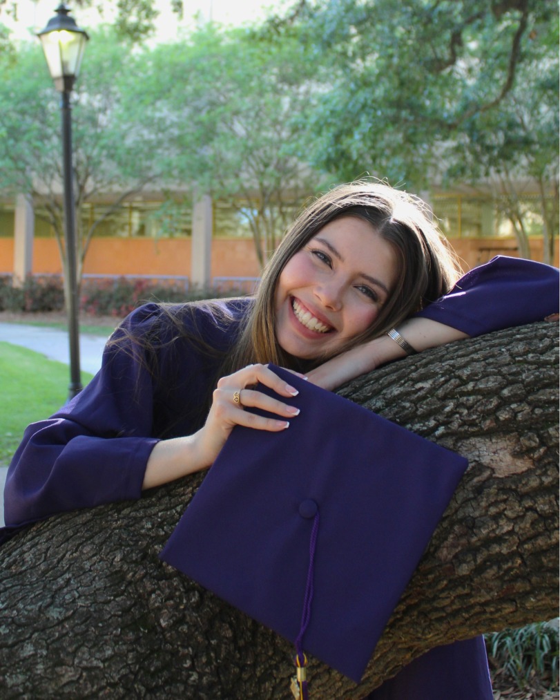 MaKenlee Price in her commencement regalia behind the LSU library