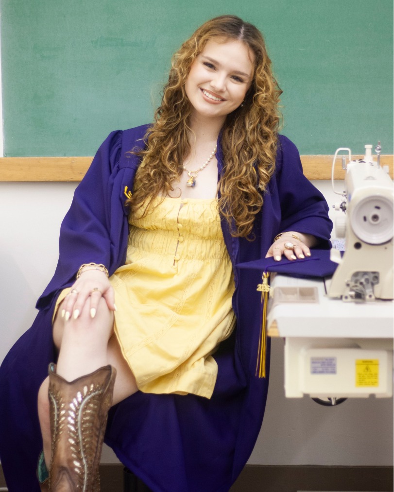 Martha Rigney at her sewing table in her commencement regalia