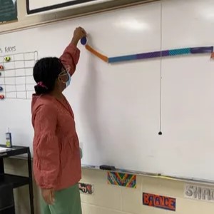Teacher drawing on white board Taylor Rising is an art teacher at McKinley Middle Academic Magnet School in Baton Rouge.