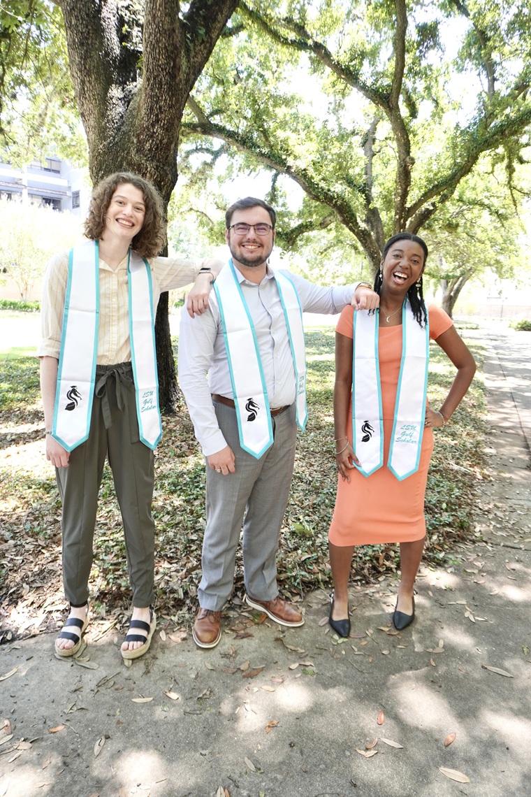 Three students posing for a graduation photo.
